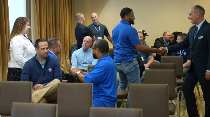 Several people standing and talking in a workshop room